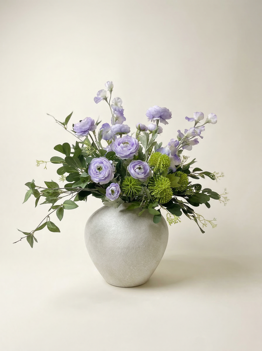 Floral arrangement in a silver vase on a light background