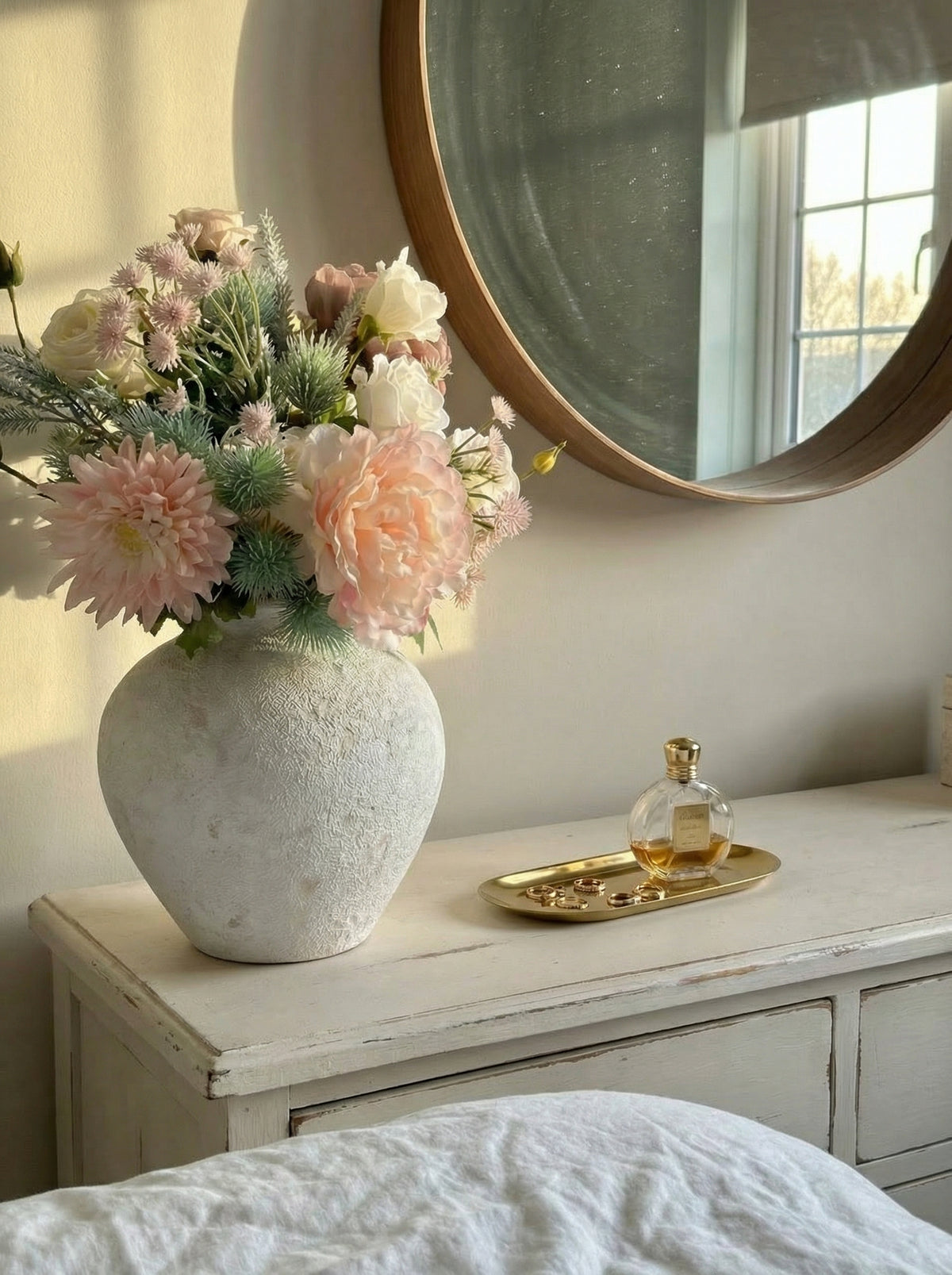 Vase with flowers on a dresser next to a mirror