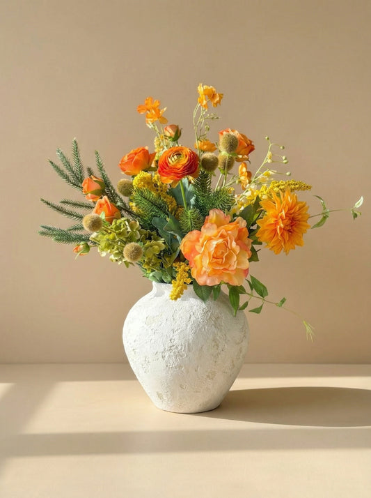 Vase with orange and yellow flowers on a beige background