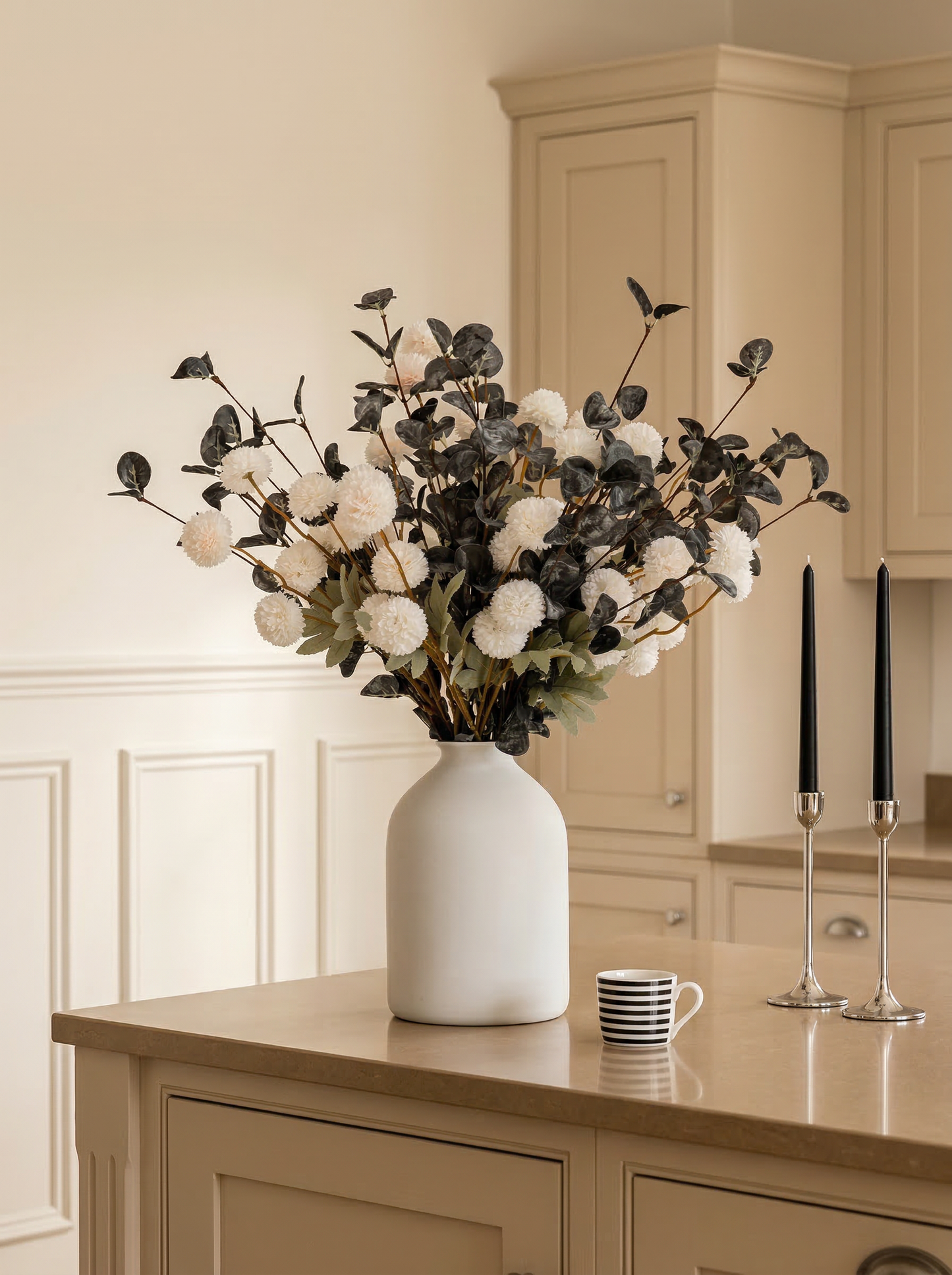 White vase with decorative flowers on a kitchen counter